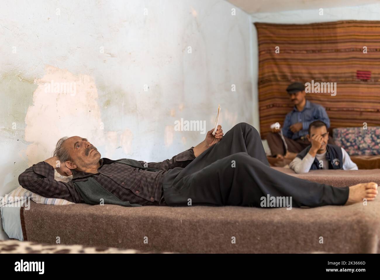 Antalya, Turkey-September 23, 2022: Wax sculpture of an old prisoner reading letter while lying on the bunk in Ulucanlar Prison Museum. Stock Photo