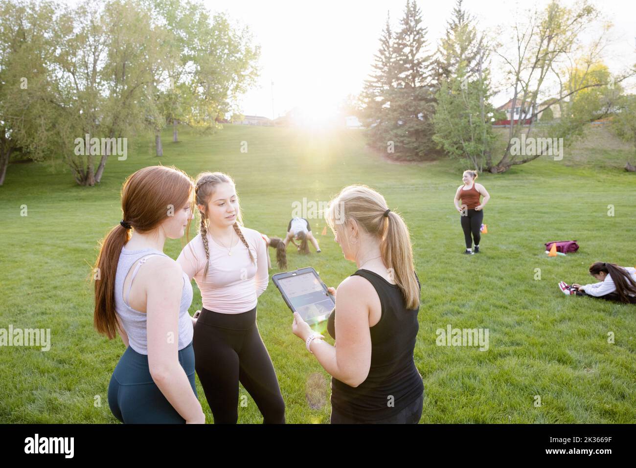 Fitness teacher and students using digital tablet at workout class Stock Photo