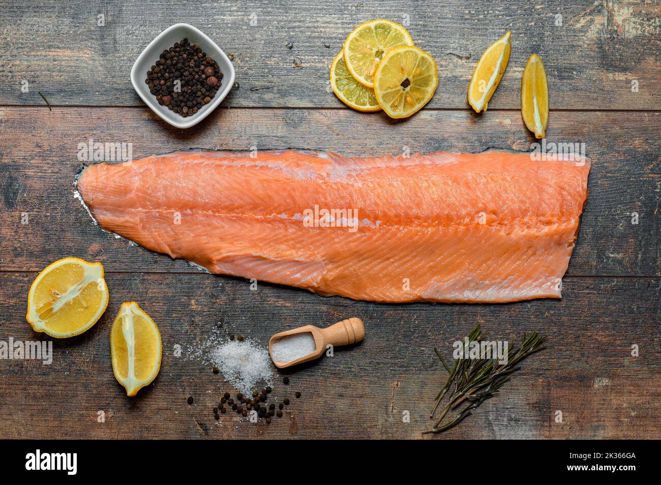 Fish fillet with culinary ingredients, herbs, salt, pepper, and lemon