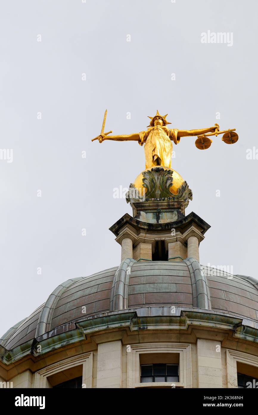 Gilded state, of a figure with a sword and scales, above the dome at The Central Criminal Court, the Old Bailey, London, England. Stock Photo