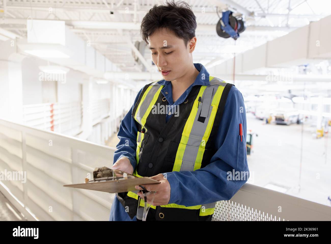 Male worker with clipboard in maintenance facility Stock Photo Alamy