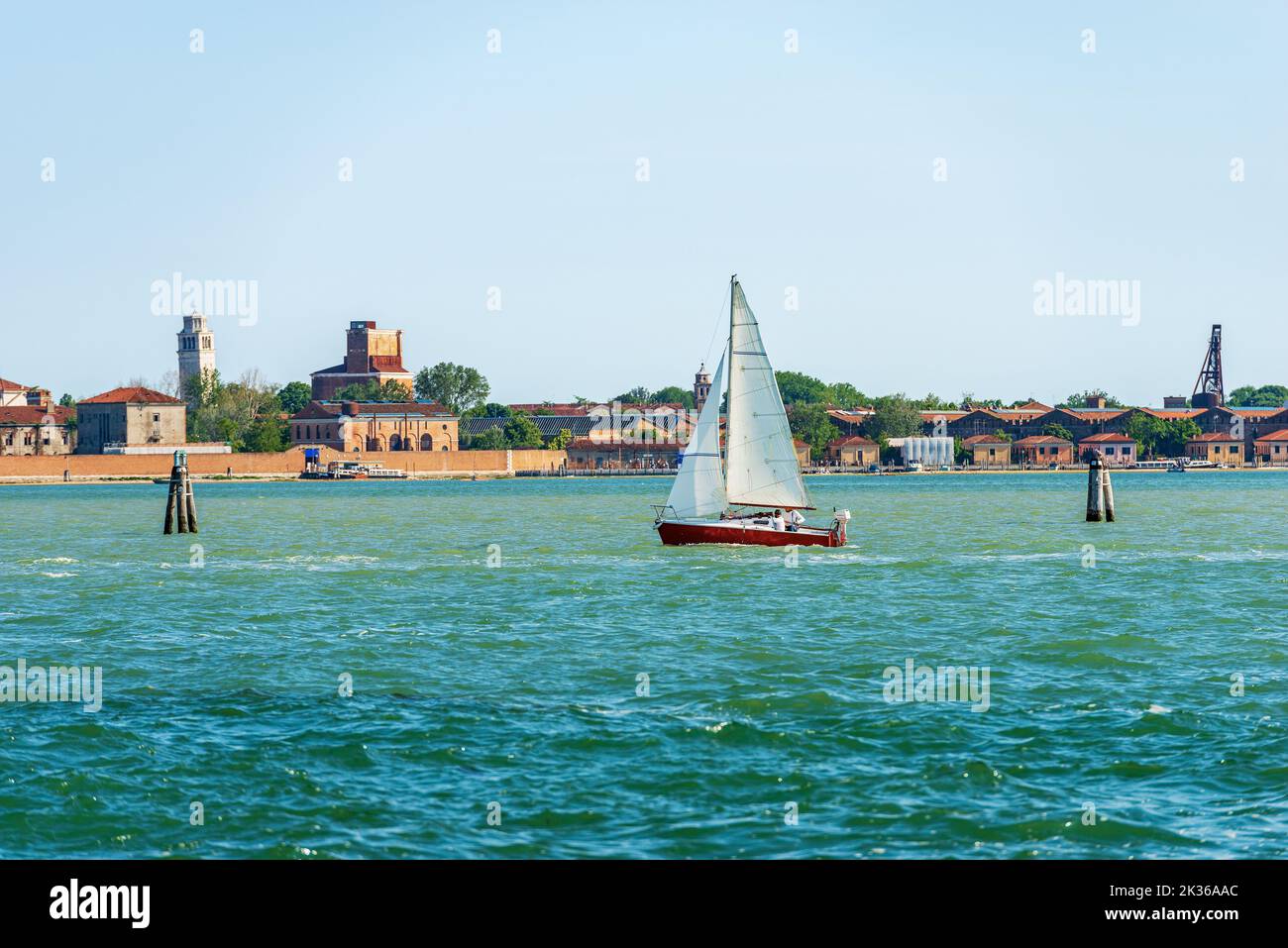 White and red sailing boat in motion in the Venetian Lagoon on a sunny spring day. Venice, Veneto, Italy, southern Europe. UNESCO world heritage site. Stock Photo
