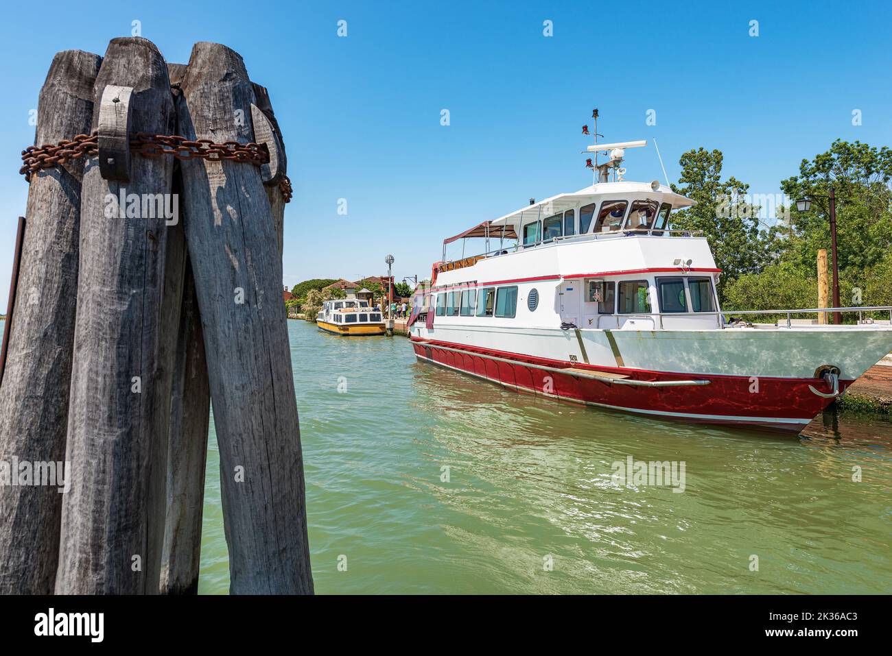 Two ferries moored in the port of the Torcello Island, Venetian lagoon, Venice, Veneto, Italy, Europe. Large wooden poles called Briccola (Dolphin). Stock Photo