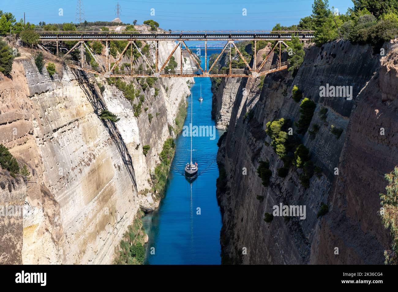 A boat sails through the very narrow Corinth Canal.The canal is connects the Gulf of Corinth in the Ionian Sea with the Saronic Gulf in the Aegean Sea. Stock Photo