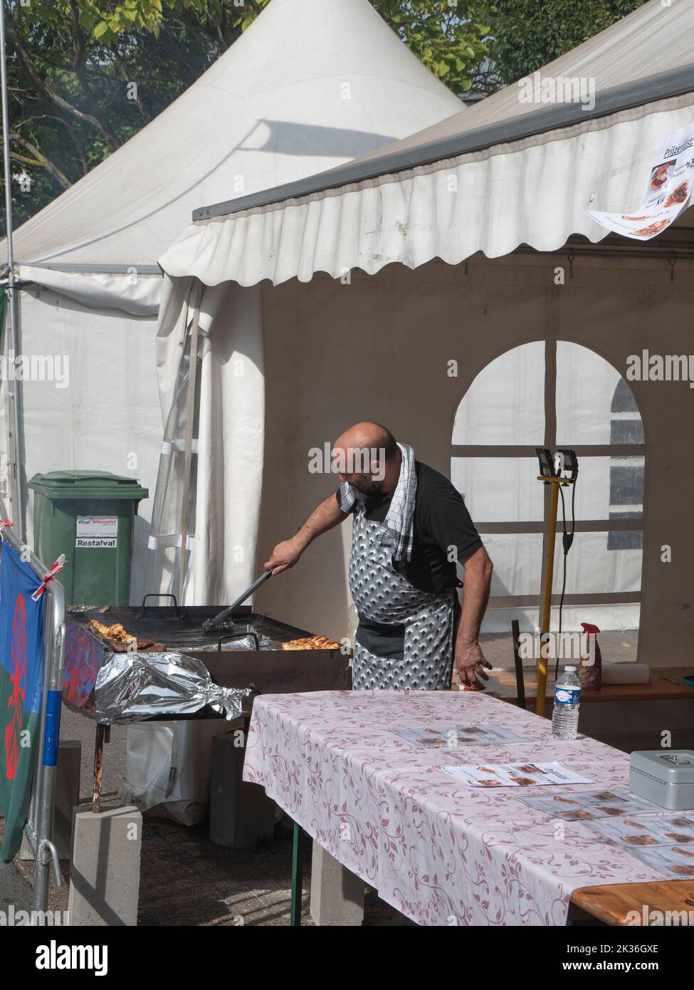 Sint Niklaas, Belgium, September 04, 2022, Man with a beard is at the barbecue at a local market with world cuisine Stock Photo