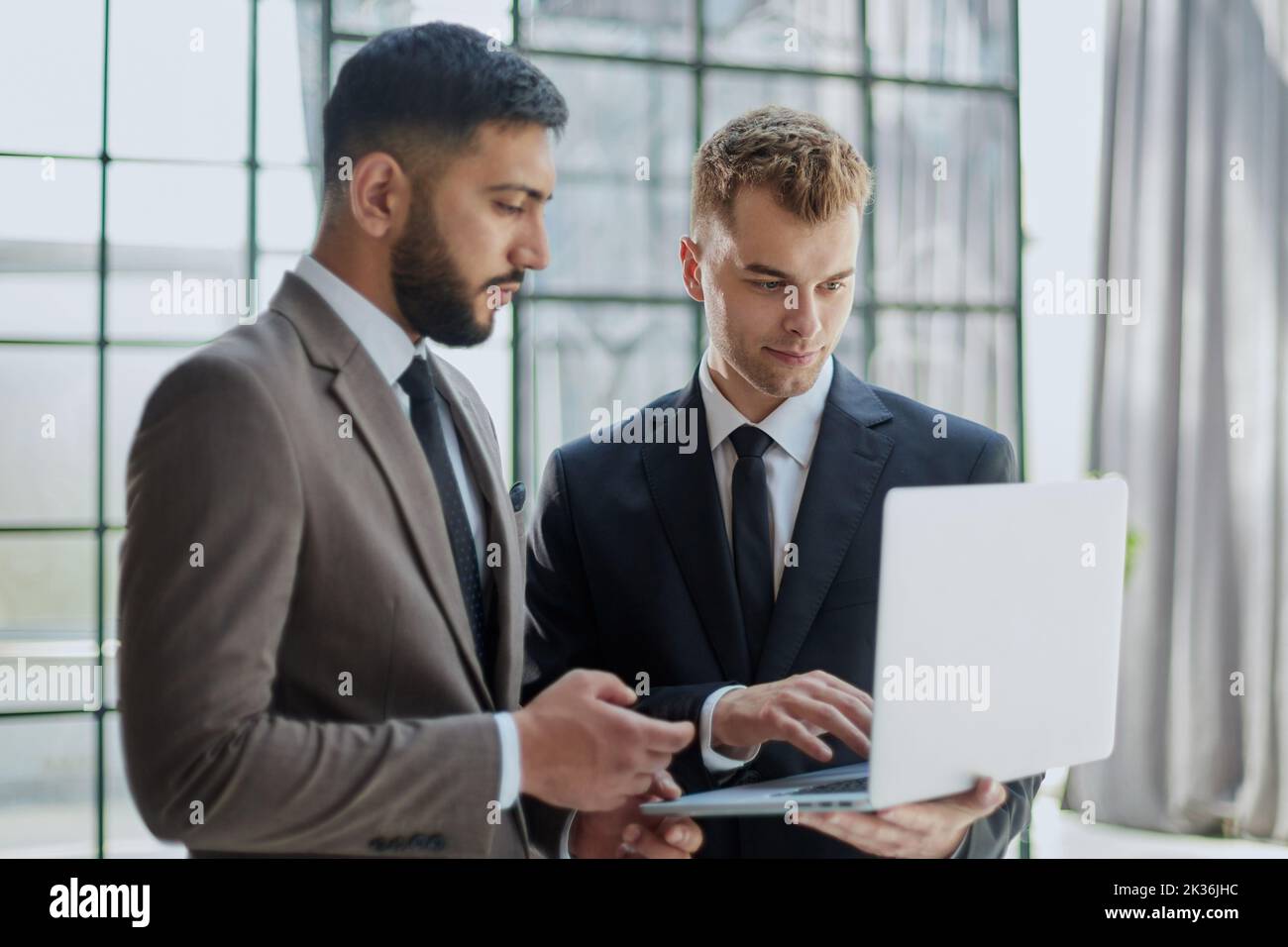 two professional businessmen discussing and using desktop computer in office Stock Photo