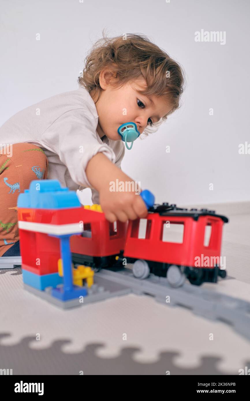 Cute toddler with toy train at home Stock Photo Alamy