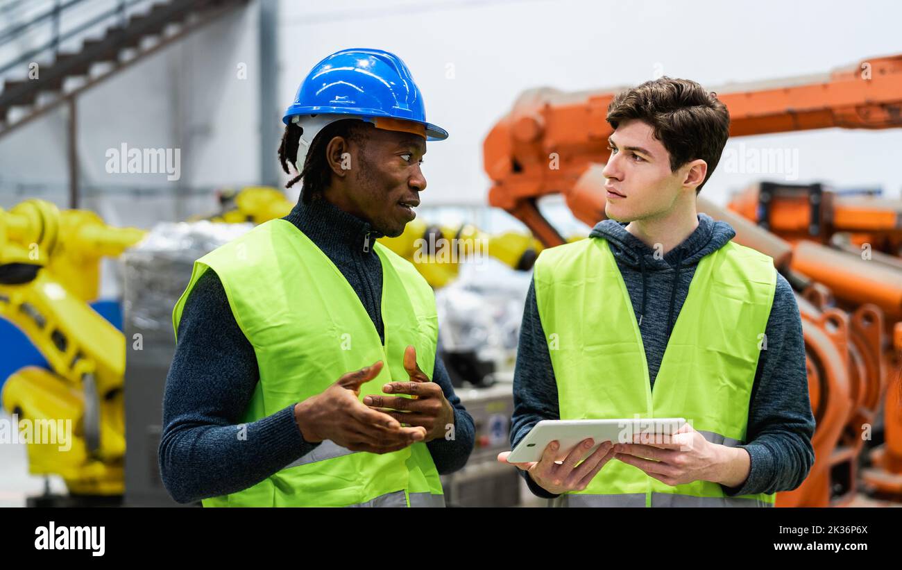 Multiracial engineers working in robotic factory - Tech industry concept Stock Photo