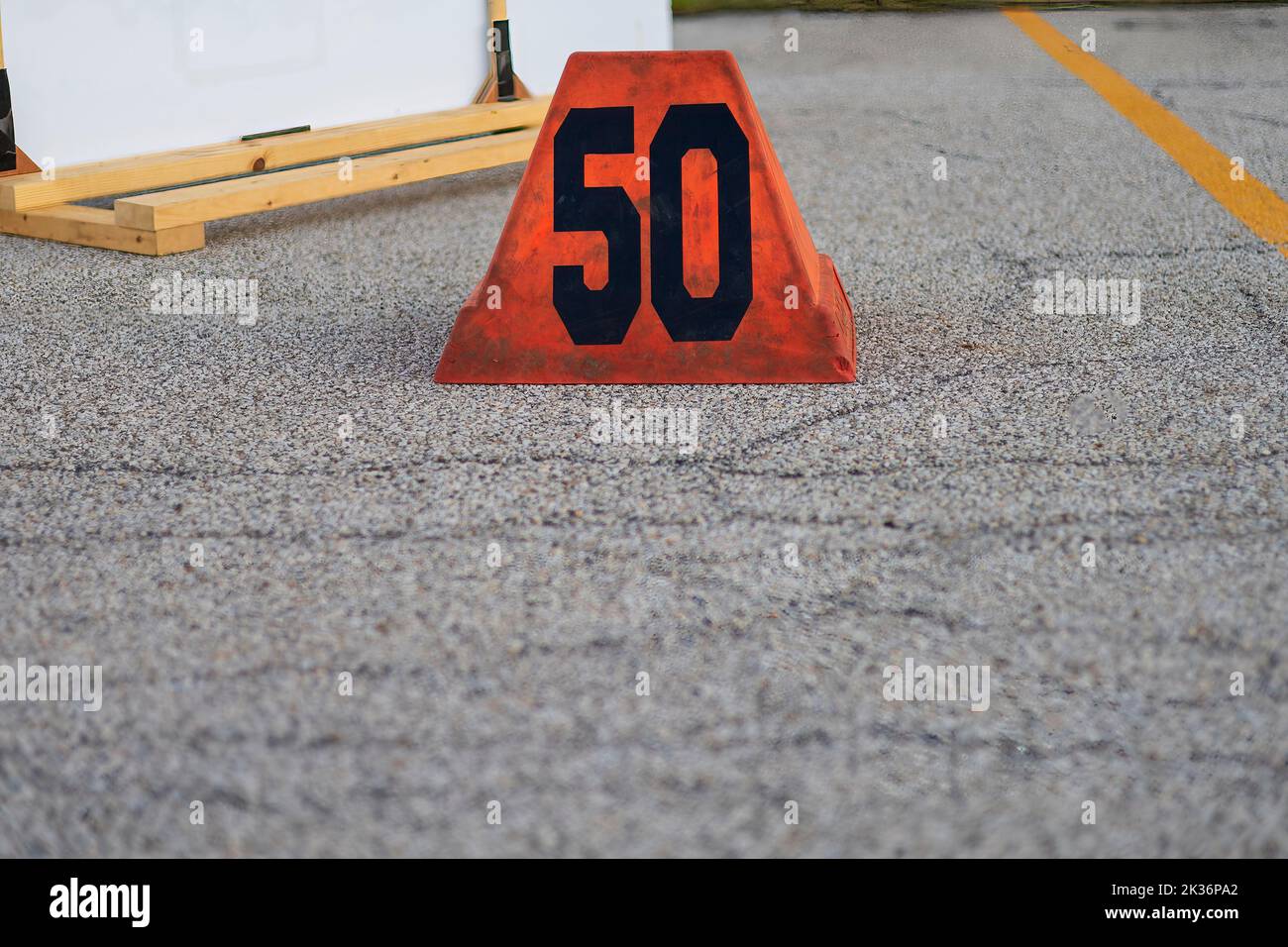 orange fifty yard line marker ready for a marching band rehearsal Stock