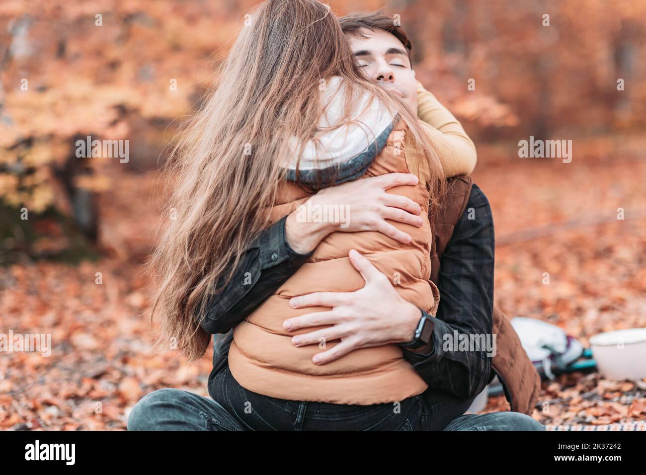 Young, romantic couple in tight embrace in the woods. Autumn time Stock Photo