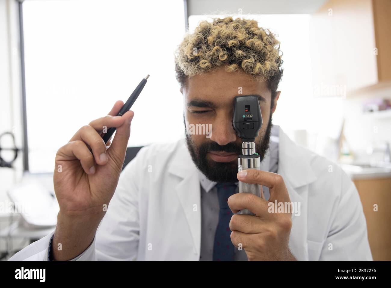 POV optometrist using ophthalmoscope in optometry exam room Stock Photo