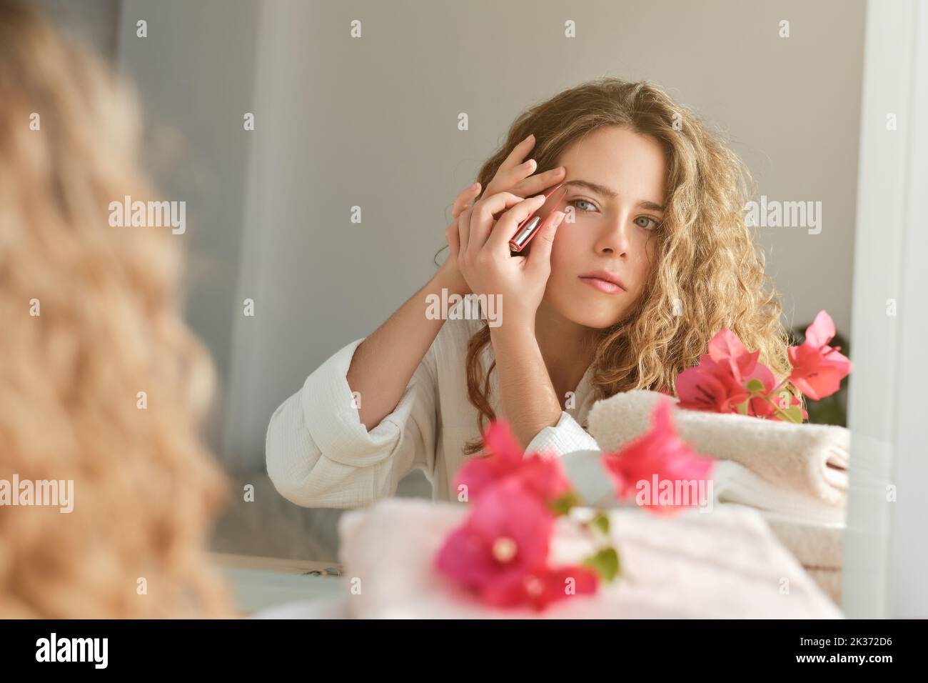 Woman plucking eyebrows while looking in mirror Stock Photo Alamy