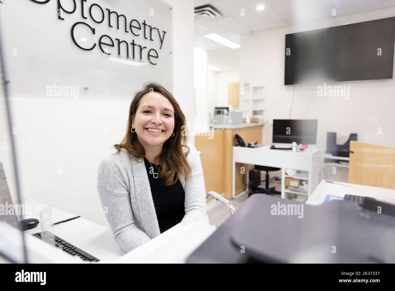 Portrait happy female receptionist working in optometry center Stock Photo Alamy