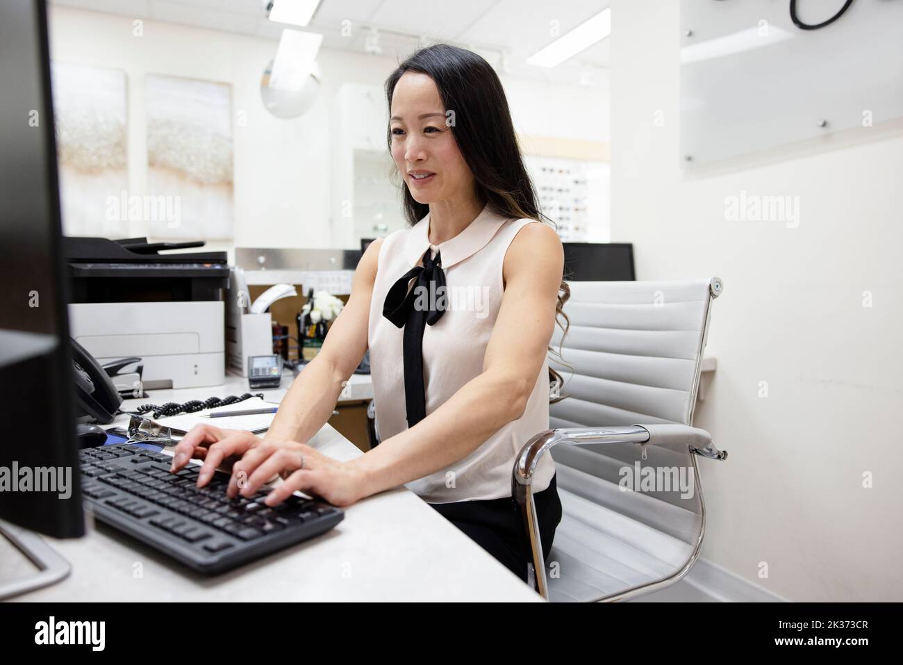 Female receptionist working at computer in optometry center Stock Photo Alamy
