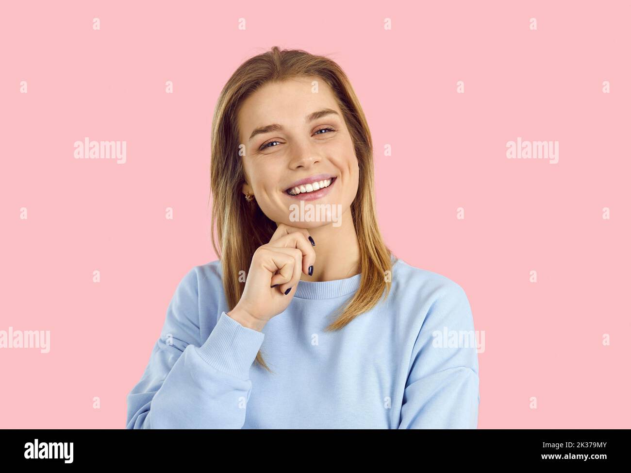 Portrait of smiling girl on pink background laughing Stock Photo