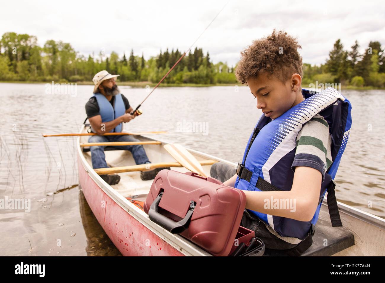 Father and son fishing in canoe on river Stock Photo Alamy