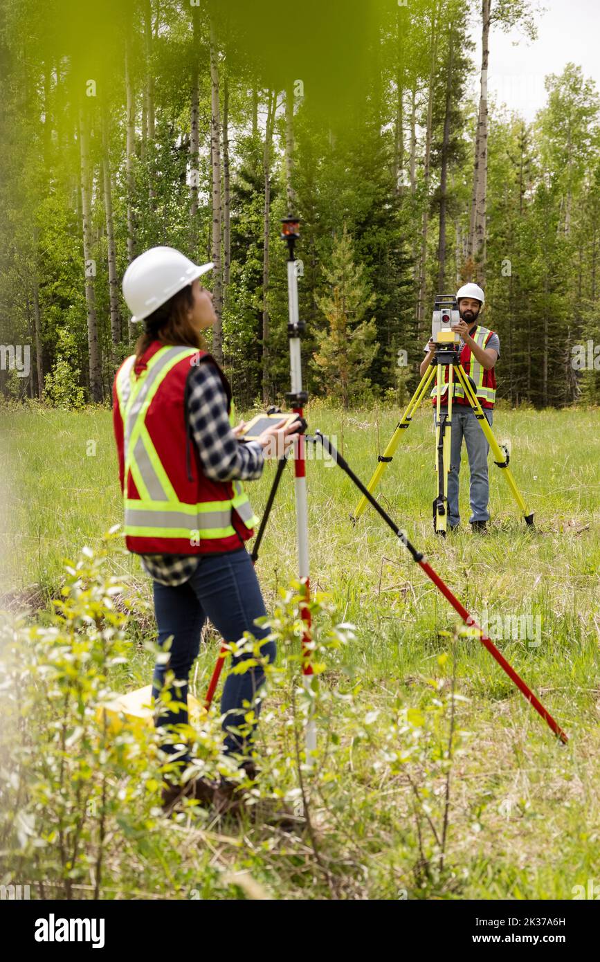 Surveyors using equipment to measure field Stock Photo Alamy