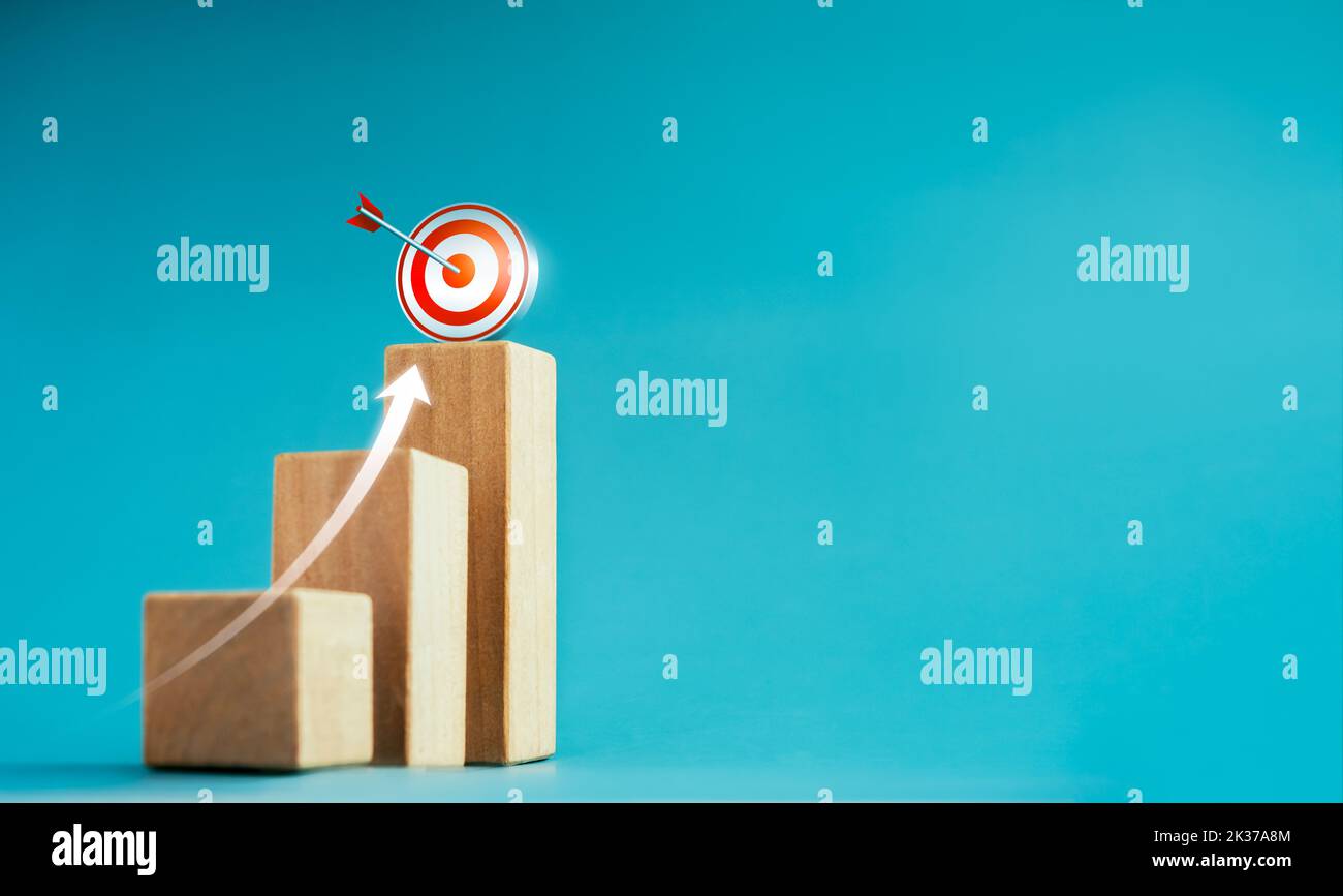 Shining rise up arrow shoot up towards the goal, 3d target icon on the top of wooden cube blocks, bar graph chart steps, business growth process, tech Stock Photo