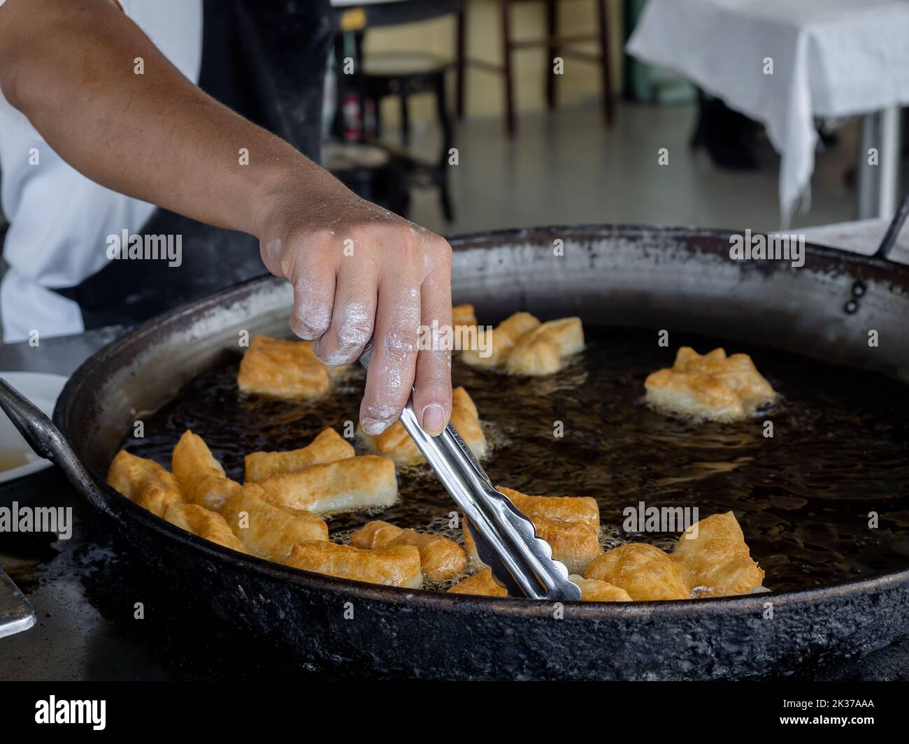 Deep-fried dough sticks or Patongko in Thai, Asian famous street food in Thailand, Chinese doughnuts. A traditional yellow crispy snack made from flou Stock Photo
