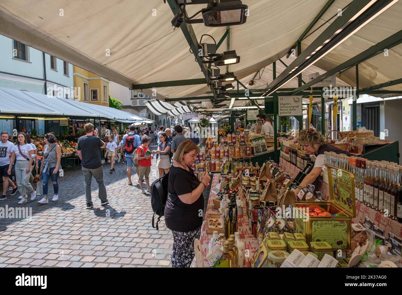 Tourists and locals shopping at the market arround the Torgglhaus in the city Bozen Italy. Stock Photo
