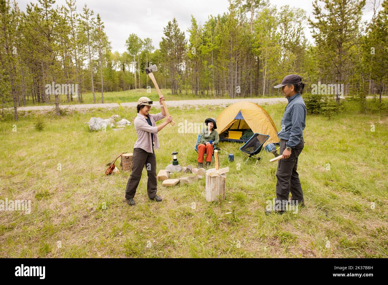Father and daughter chopping wood at forest campsite Stock Photo Alamy