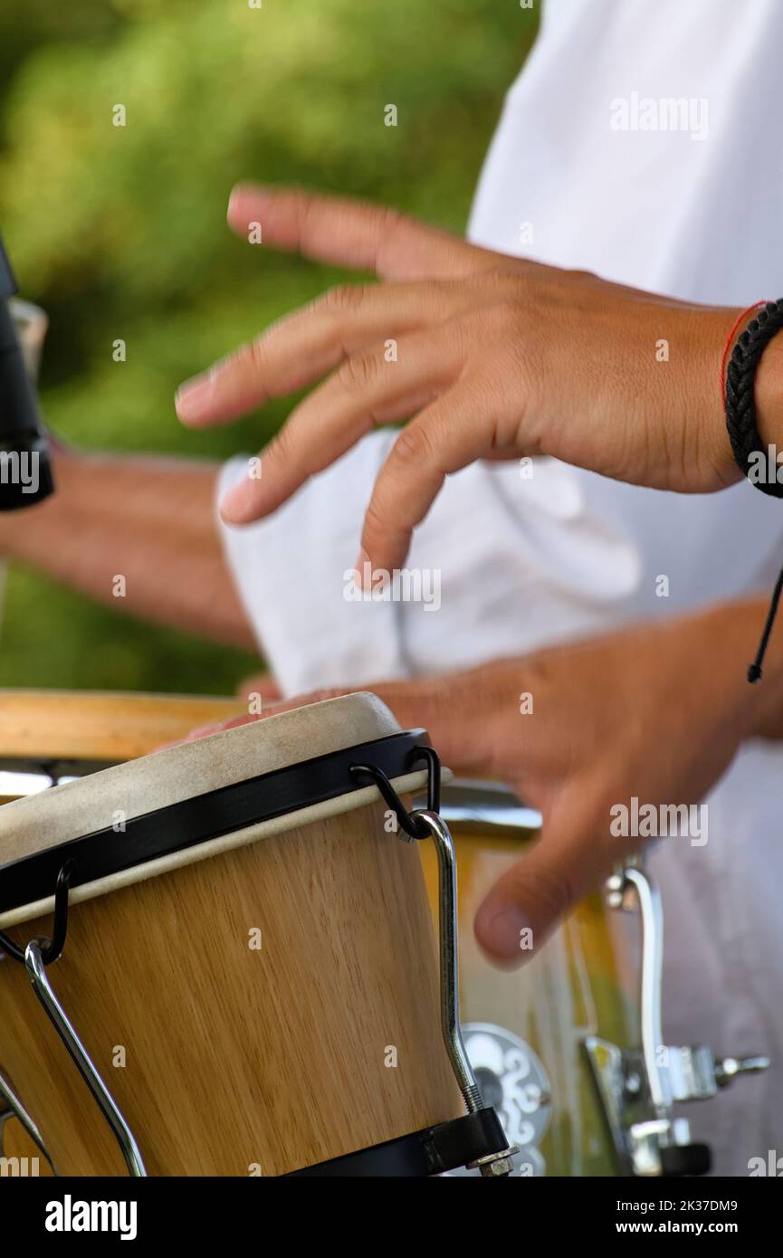 Hands Of A Salsa Band Musician With Motion Blur Playing The Bongos, Christchurch UK Stock Photo