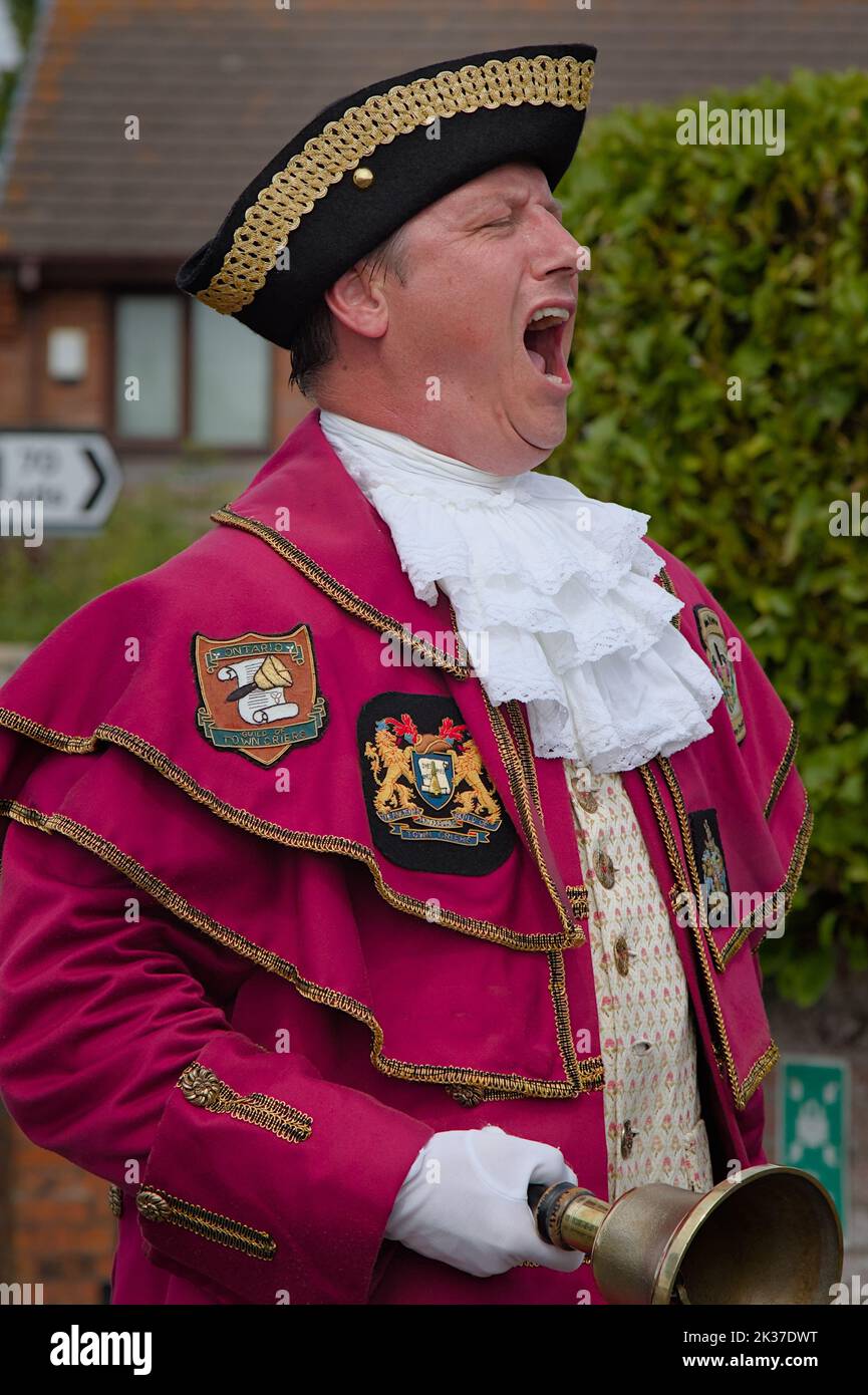 Town Crier, Bellman Shouting And Ringing His Bell In Full Costume At Christchurch Festival, Christchurch UK Stock Photo