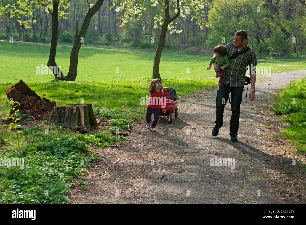 FATHER AND DAUGHTERS ON A WALK IN NYC PARK Stock Photo