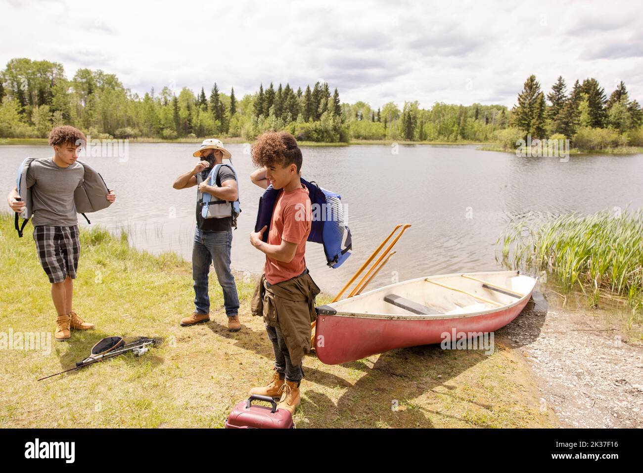 Family putting on lifejackets ready to go canoeing Stock Photo Alamy