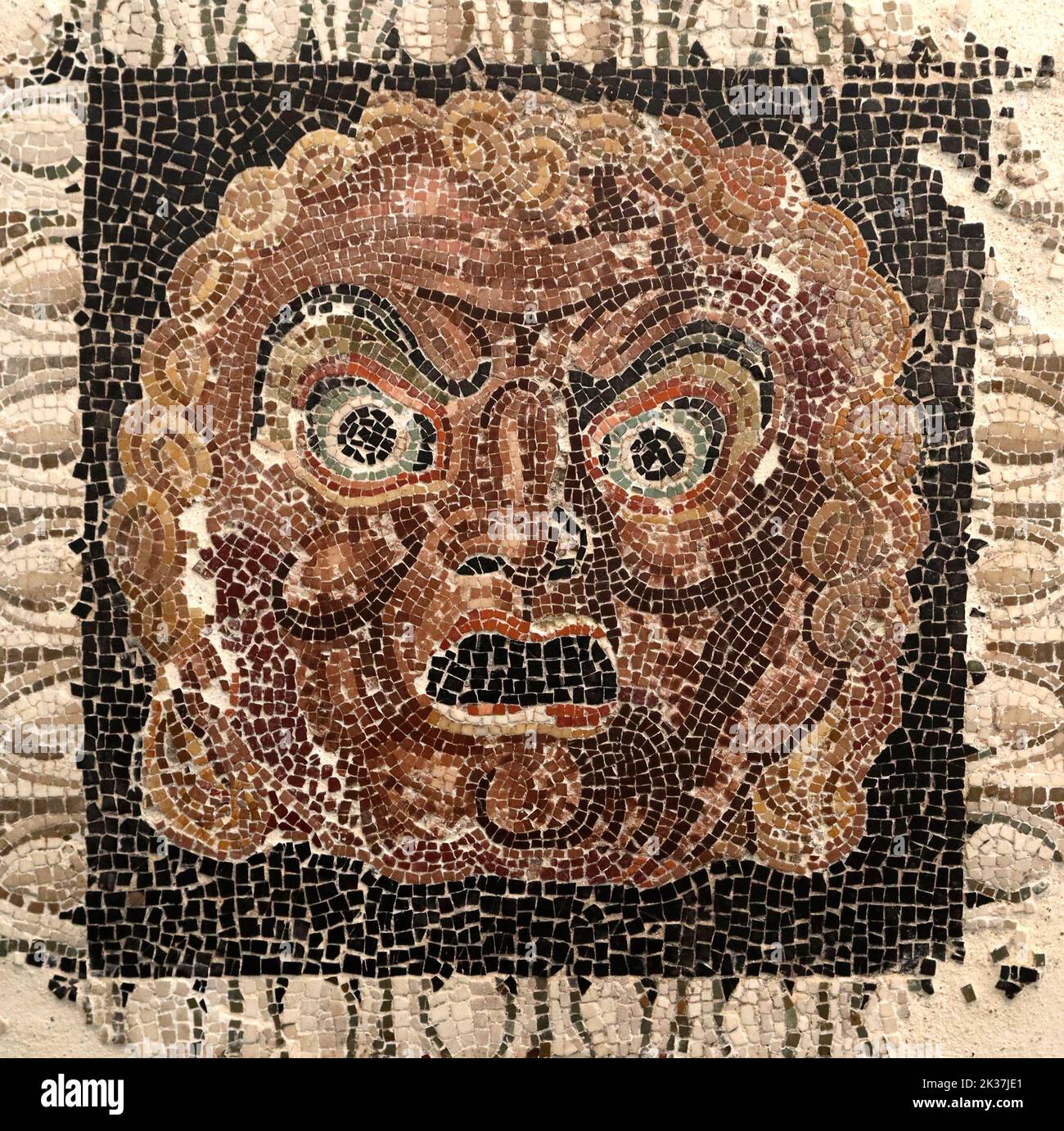 roman mosaic of small polychrome marble pieces with a face Stock Photo