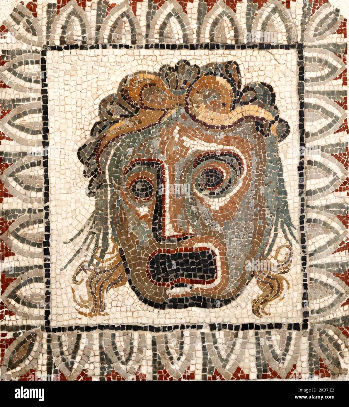 roman mosaic of small polychrome marble pieces with a face Stock Photo