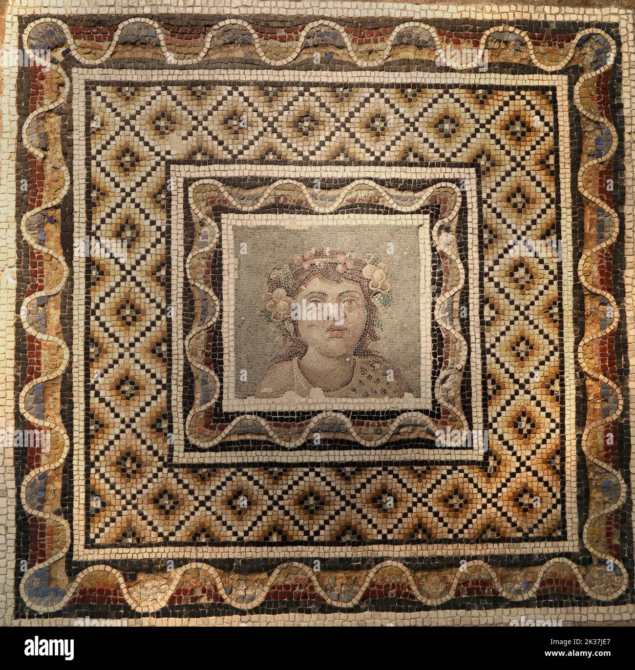 roman mosaic of small polychrome marble pieces with a human face Stock Photo