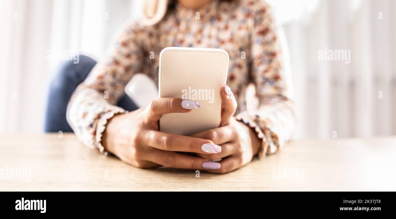 Close-up view of a woman's hands, writing a text message or browsing social networks. Stock Photo