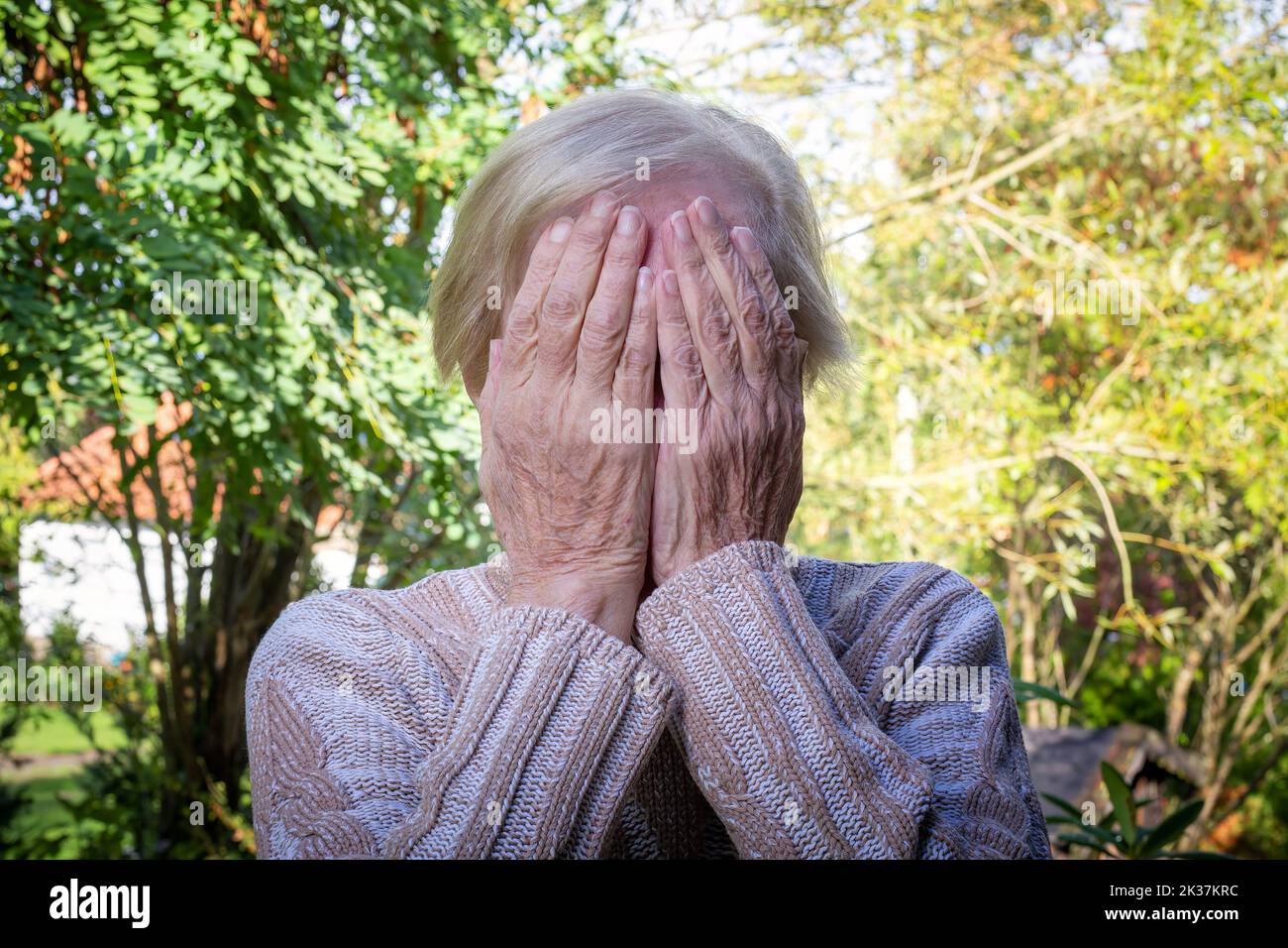 old woman covering her face with her hands Stock Photo - Alamy