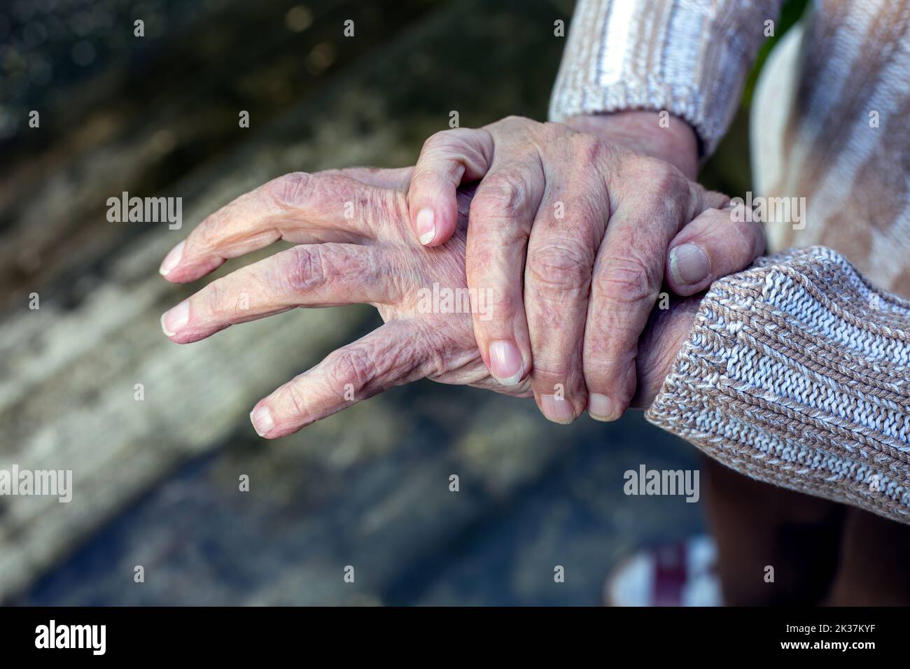 close-up of old woman rubbing her hands Stock Photo