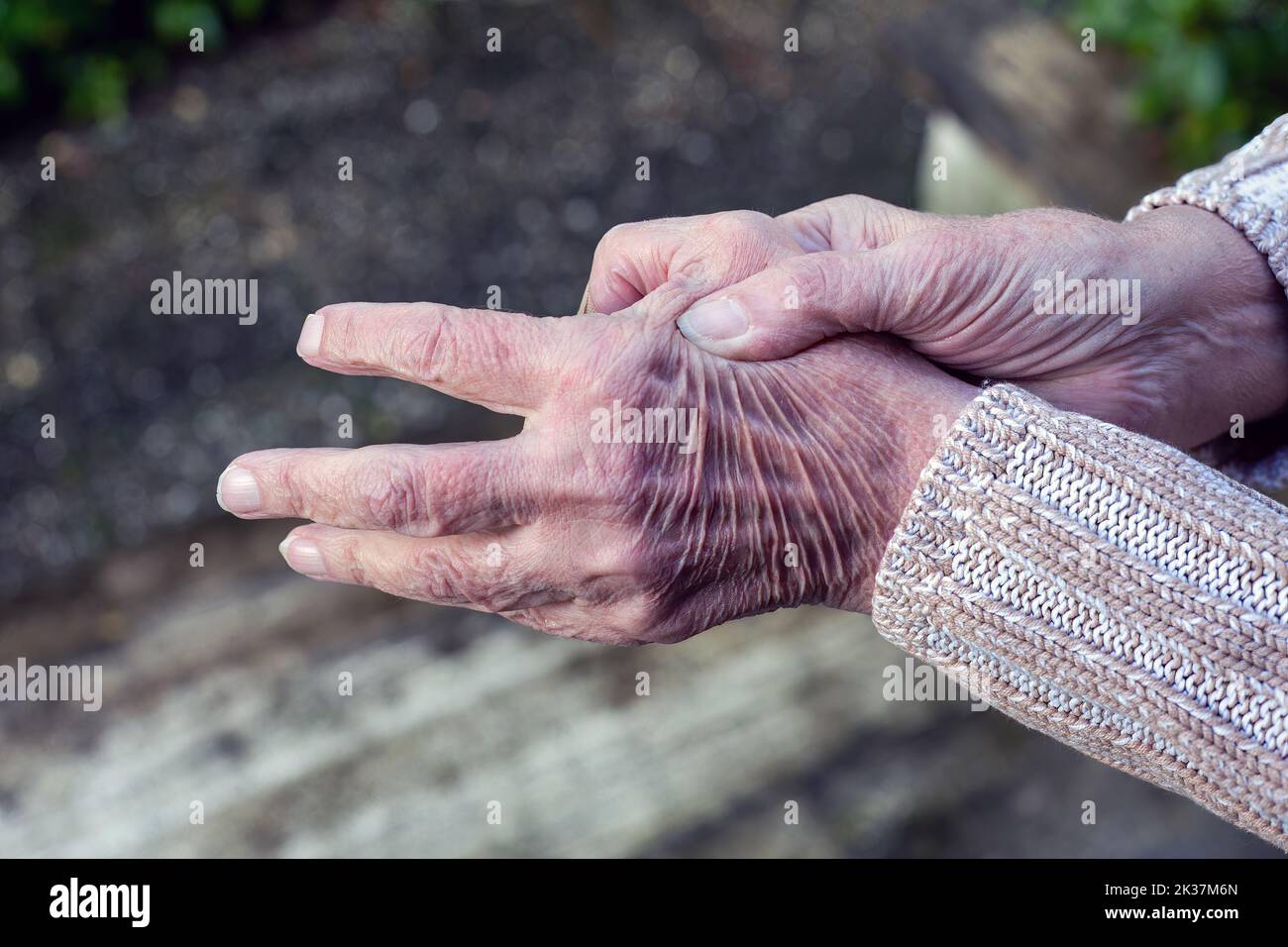close-up of old woman rubbing her hands Stock Photo