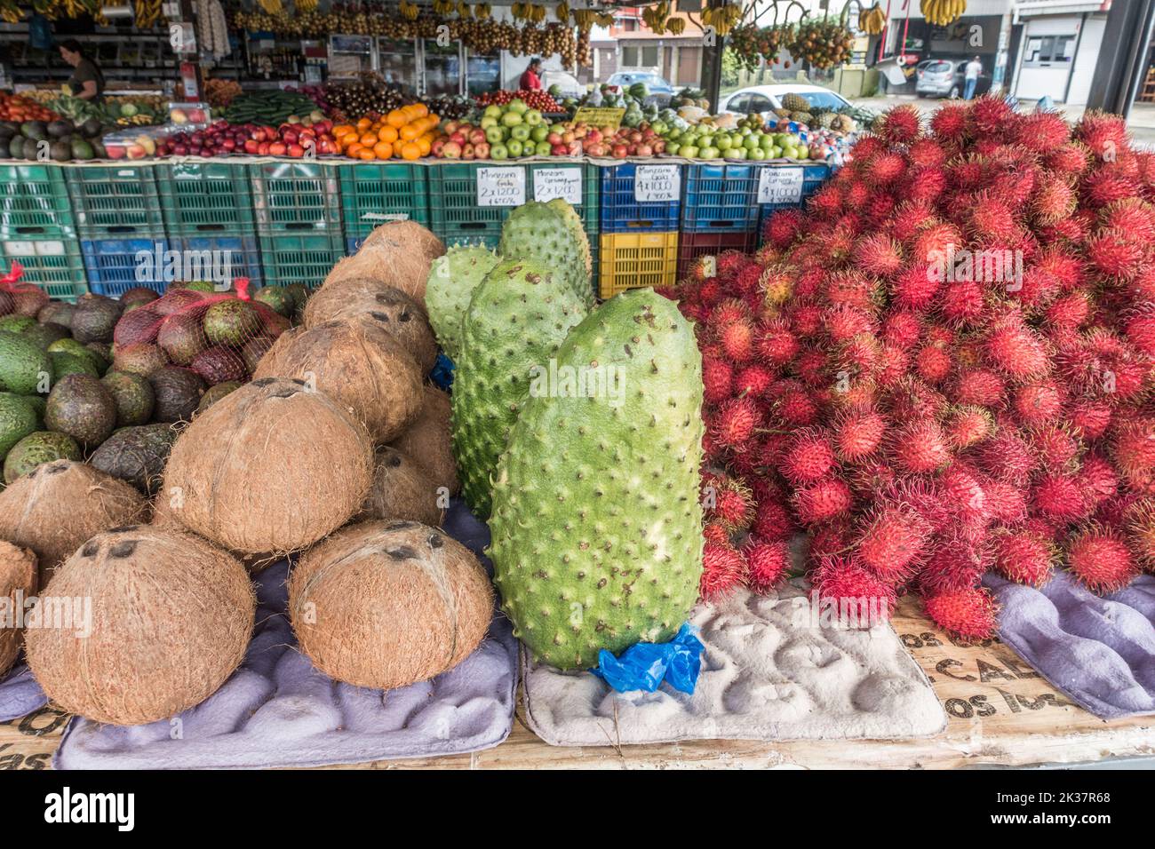 Breadfruit (Artocarpus altilis), Rambutan (Nephelium lappaceum) and coconuts (Cocos nucifera) and other fruit for sale at a market in Costa Rica. Stock Photo