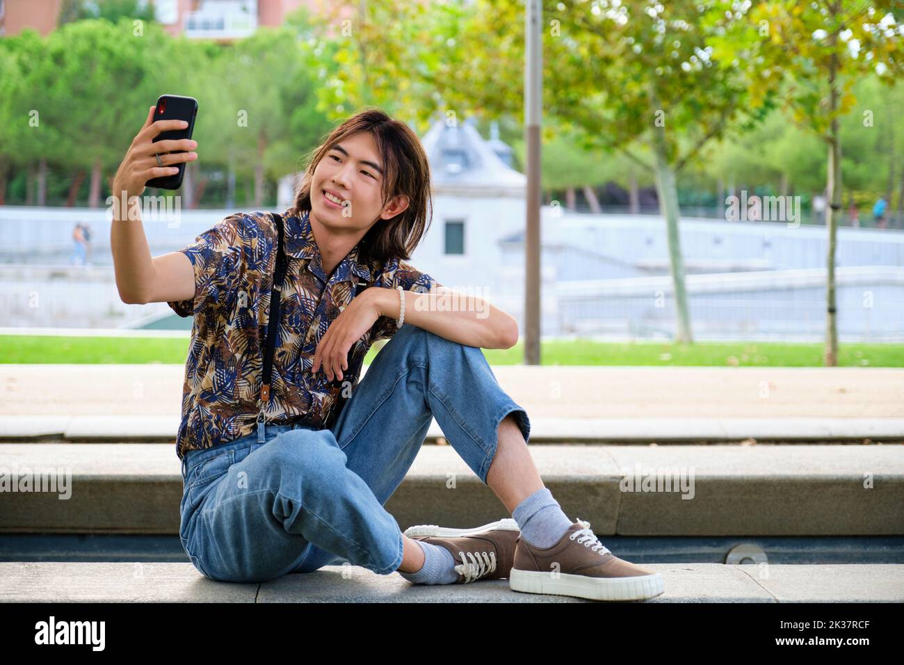Asian guy taking a selfie with the smartphone at street. Stock Photo