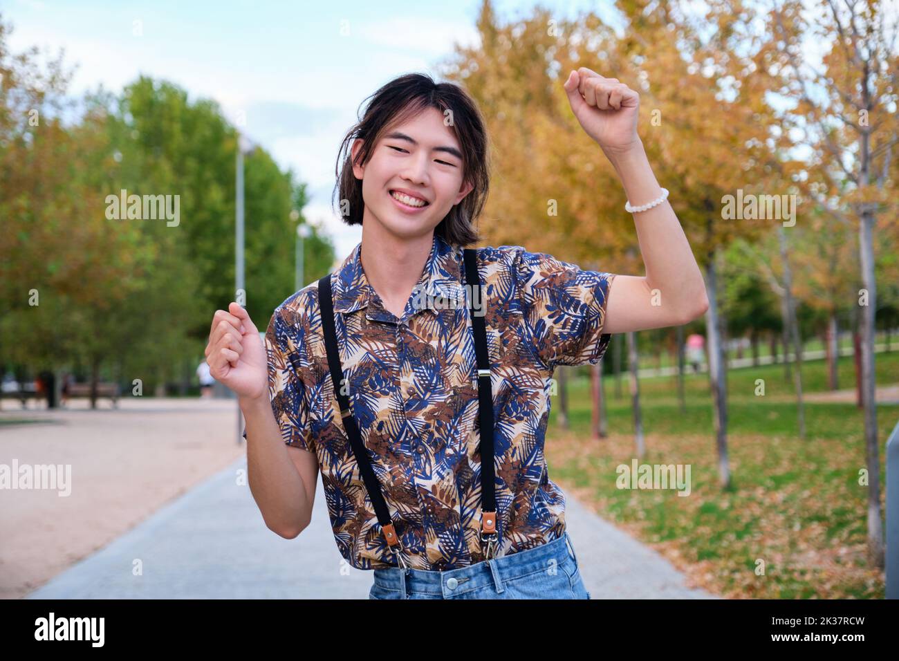 Taiwanese guy smiling and dancing rock and roll in a park. Stock Photo