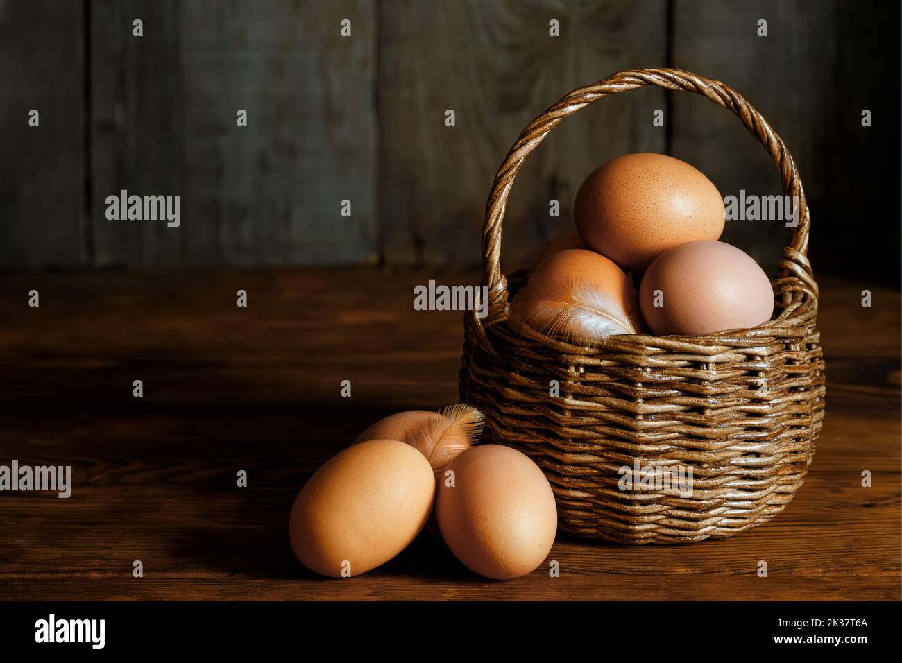 wicker basket with chicken eggs on table Stock Photo