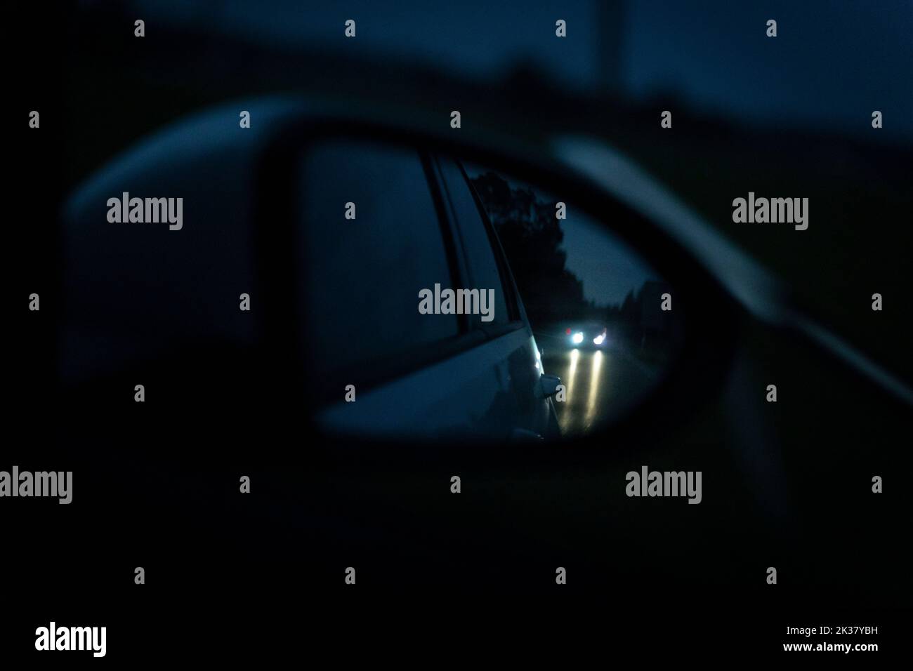 23 September 2022: View Through The Rearview Mirror Of A Moving Car At Night. Symbol Image Traffic At Night, Accident And Overtaking Stock Photo