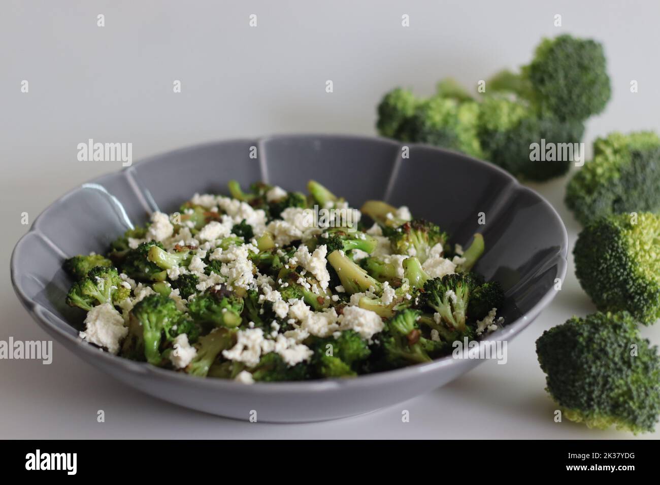 Broccoli with feta cheese. Sauteed broccoli florets sprinkles with served with crumpled feta