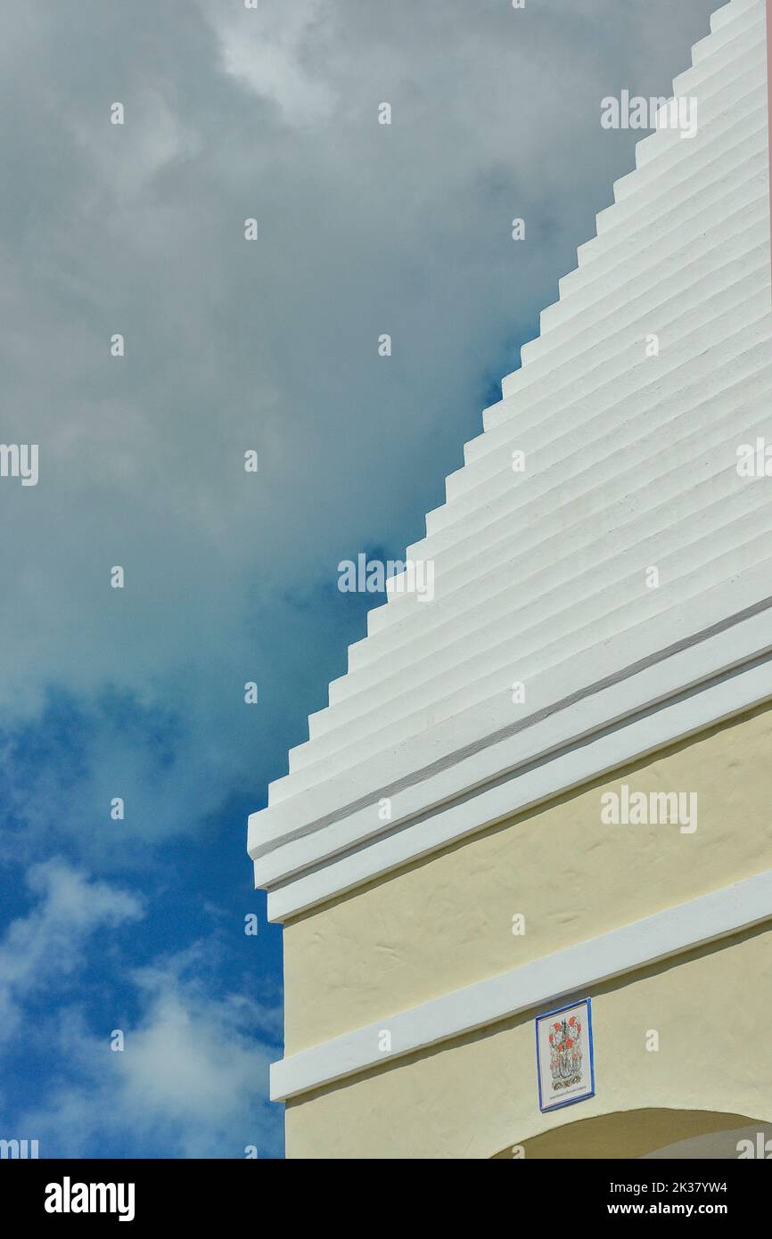 Hamilton Bermuda Architecture Close Up Abstract Shapes Textures Yellow Building White Ridged Roof against Deep Blue sky with Grey Clouds Stock Photo