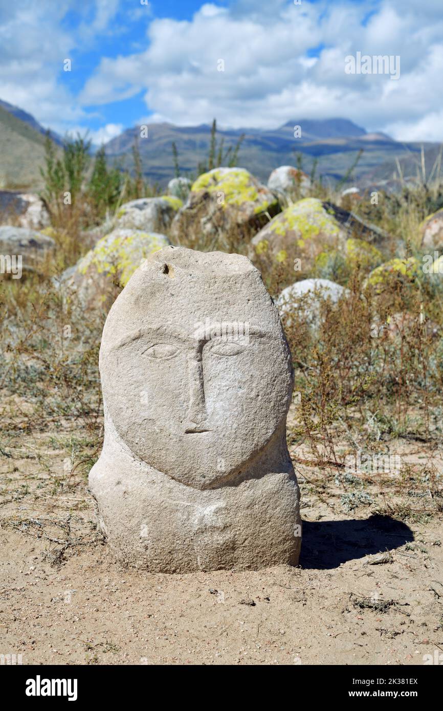 Ancient turkic stone statue depictures a man against mountains. VII-X ...