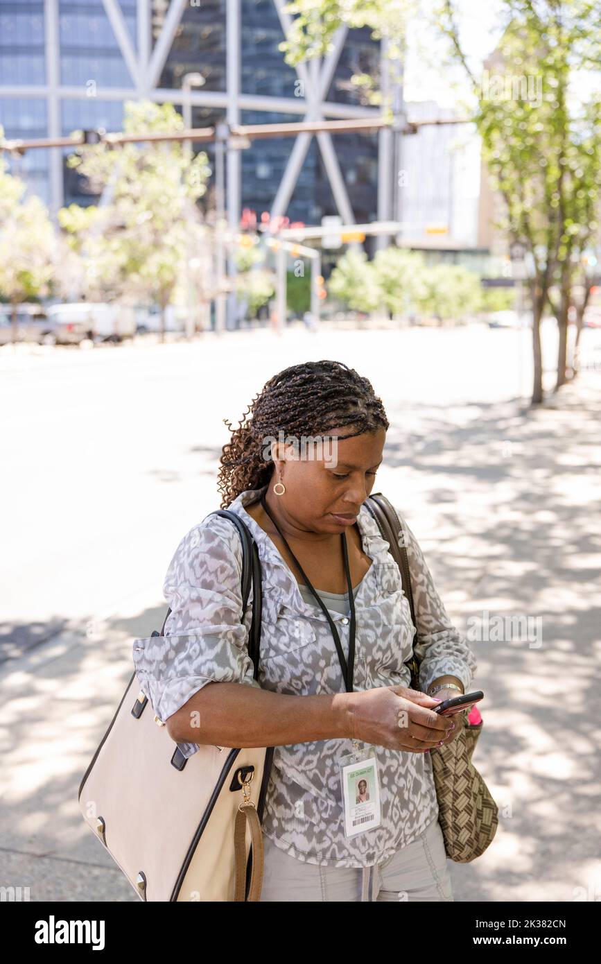 High angle view of woman with cornrow hair texting on phone Stock Photo