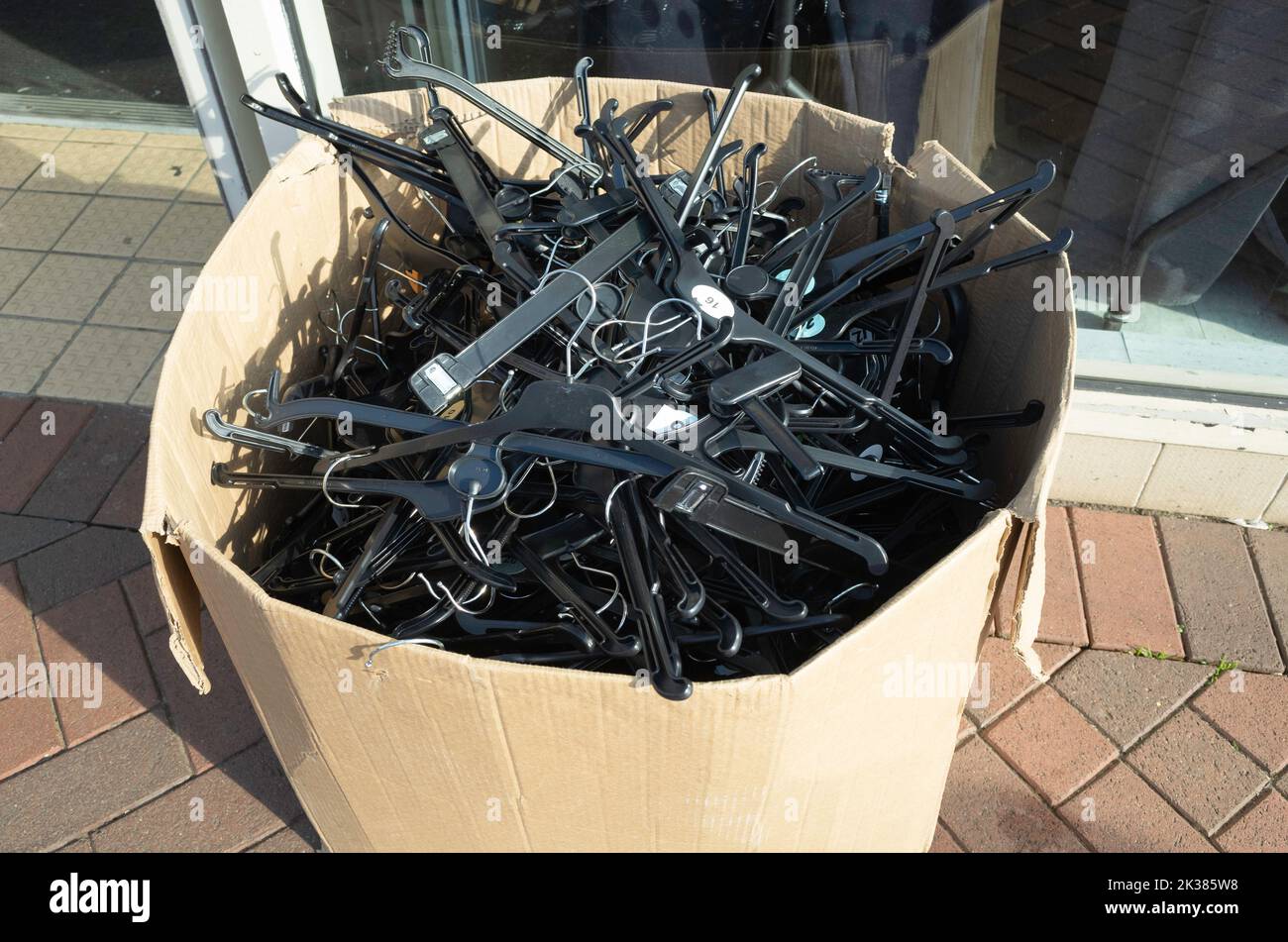 Surplus plastic coat hangers outside a shop which can be taken free of charge for personal use Stock Photo