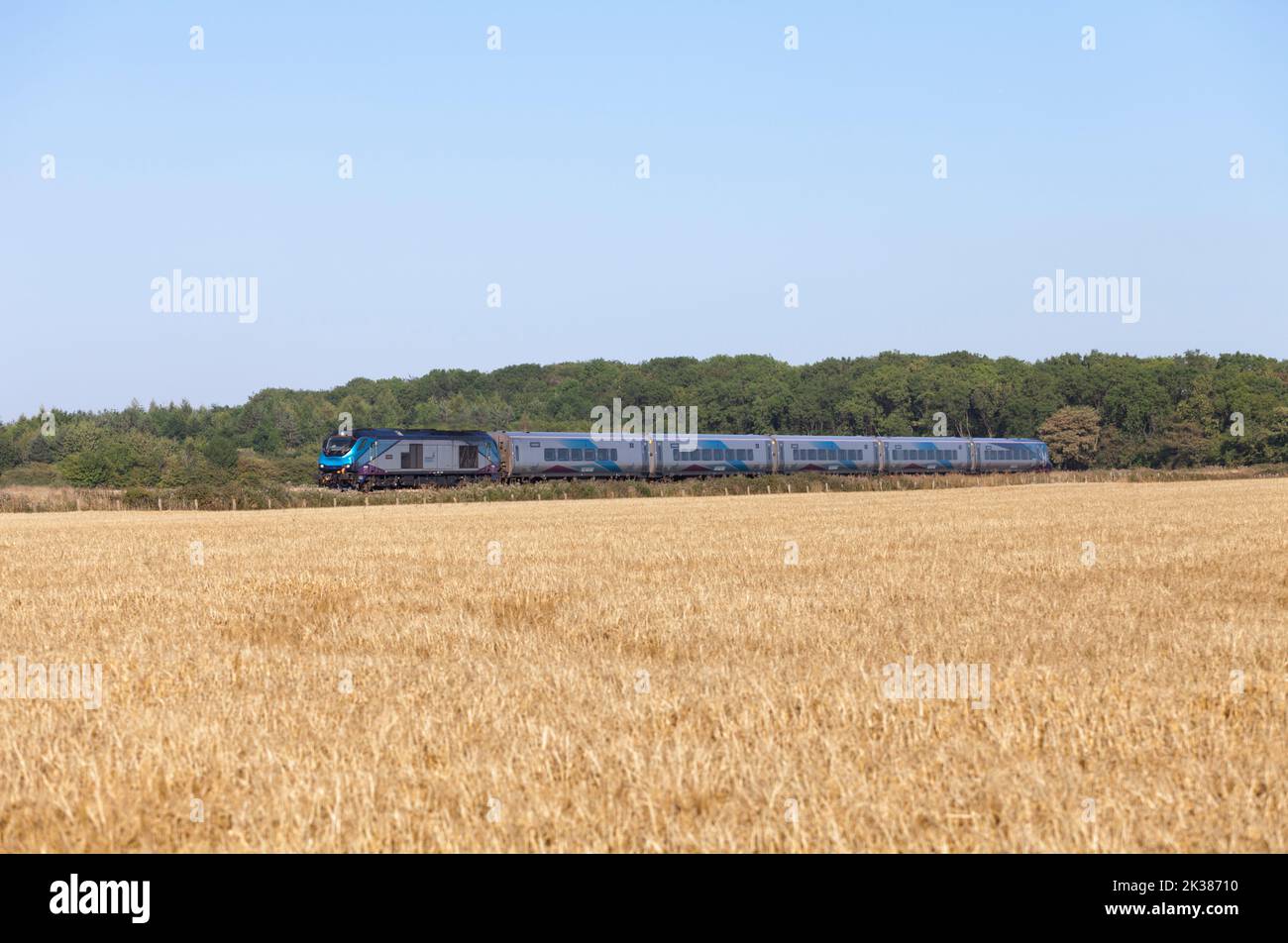 First Transpennine Express Nova 3 train with a class 68 locomotive passing arable land in Lincolnshire Stock Photo