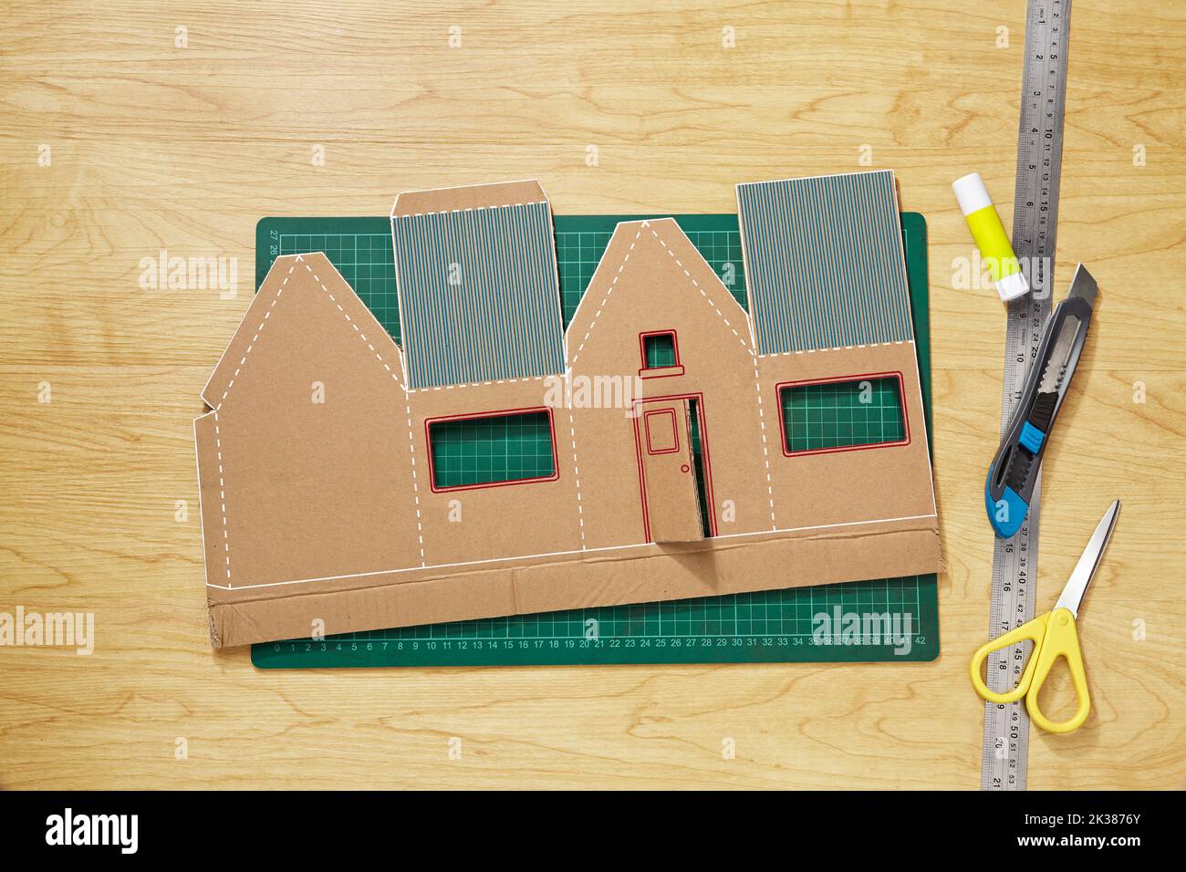 A colourful craft pattern from cardboard that has been cut, ready to be shaped and glued into a miniature house Stock Photo