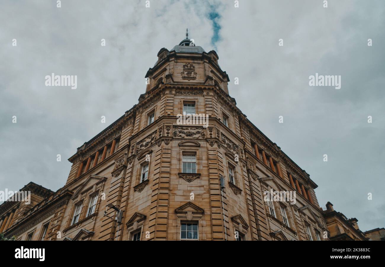 A low angle shot of building facade under cloudy sky in Glasgow Stock ...