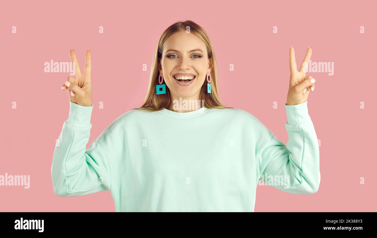 Happy beautiful young fashion model smiling and showing peace, love and victory signs Stock Photo